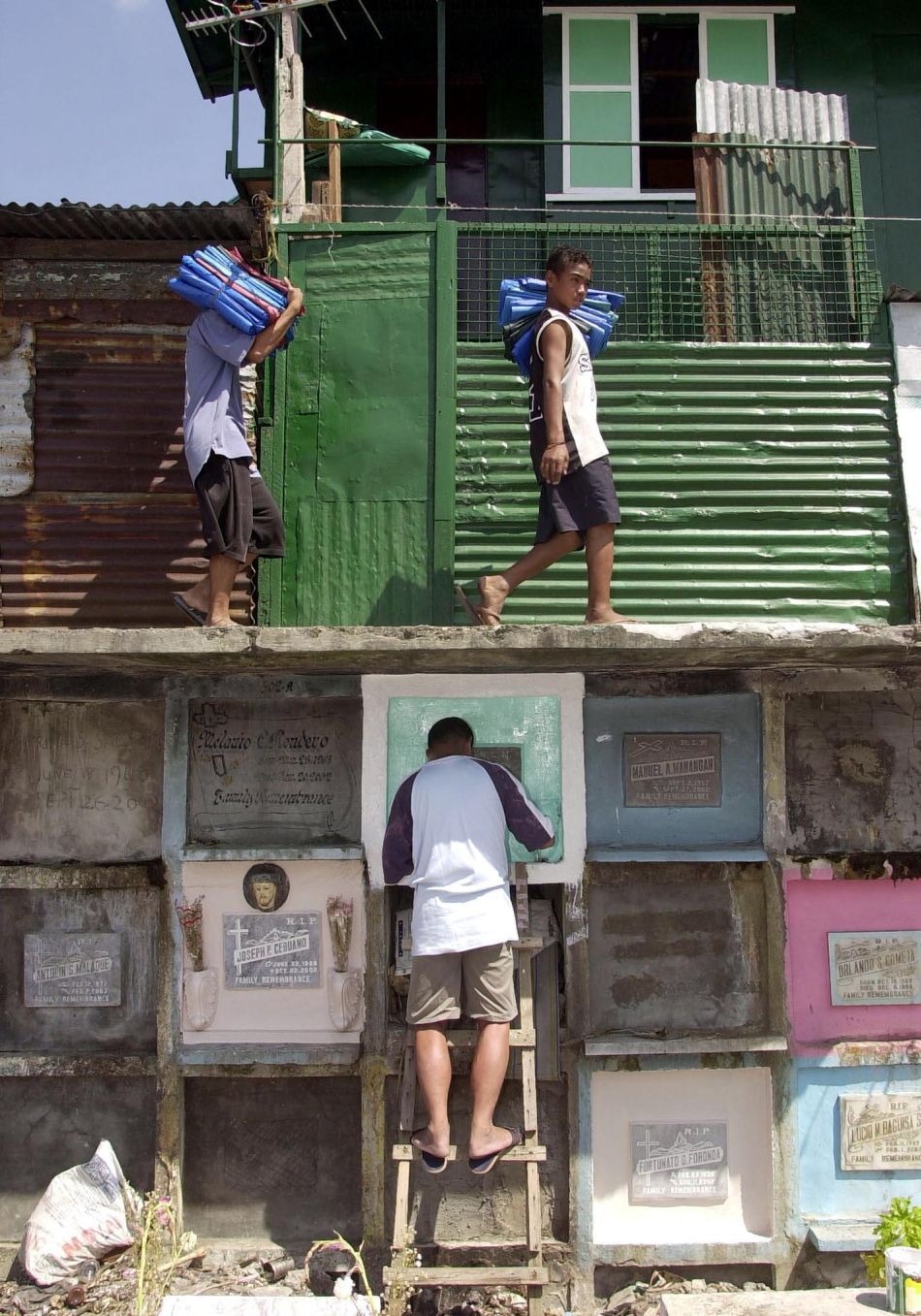 Un bărbat curăţă un mormânt în Cimitirul de Nord din Manila (Filipine), 29 Octombrie 2003