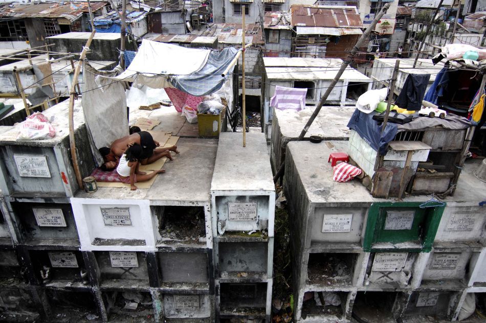 O familie locuişte în casa lor de tip baracă construită pe morminte în interiorul Cimitirului Municipal din Manila (Filipine), 30 Octombrie 2009