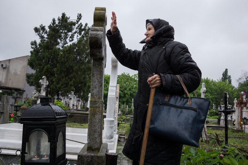 O bătrână la mormintele părinţilor săi din cimitirul Băneasa.