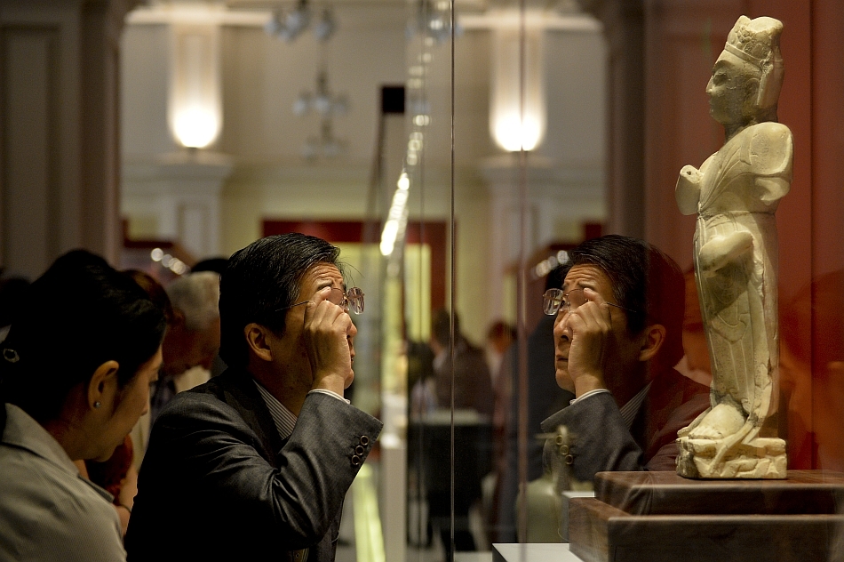 Un barbat priveste catre exponatele prezentate in timpul expozitiei-eveniment “Comorile Chinei”, organizata de Muzeul National de Istorie a Romaniei in parteneriat cu Art Exhibition China