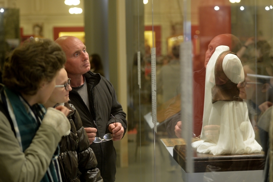 O femeie priveşte spre o vitrină în care sunt expuse piese vestimentare, într-o expoziţie din Muzeul Naţional de Istorie a României, în cadrul Nopţii Albe a Muzeelor, în Bucureşti, sâmbătă, 17 mai 2014. 